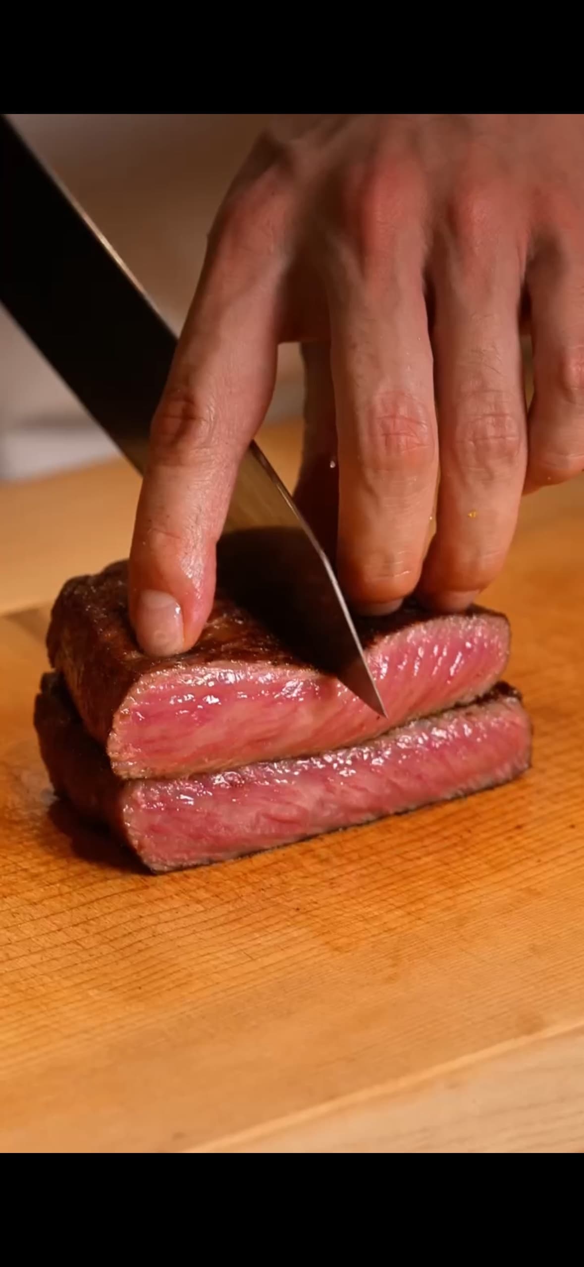 A chef carving a perfectly cooked Kobe beef steak