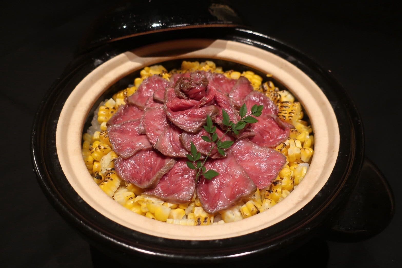 Wagyu and grilled corn arranged in a Japanese clay pot