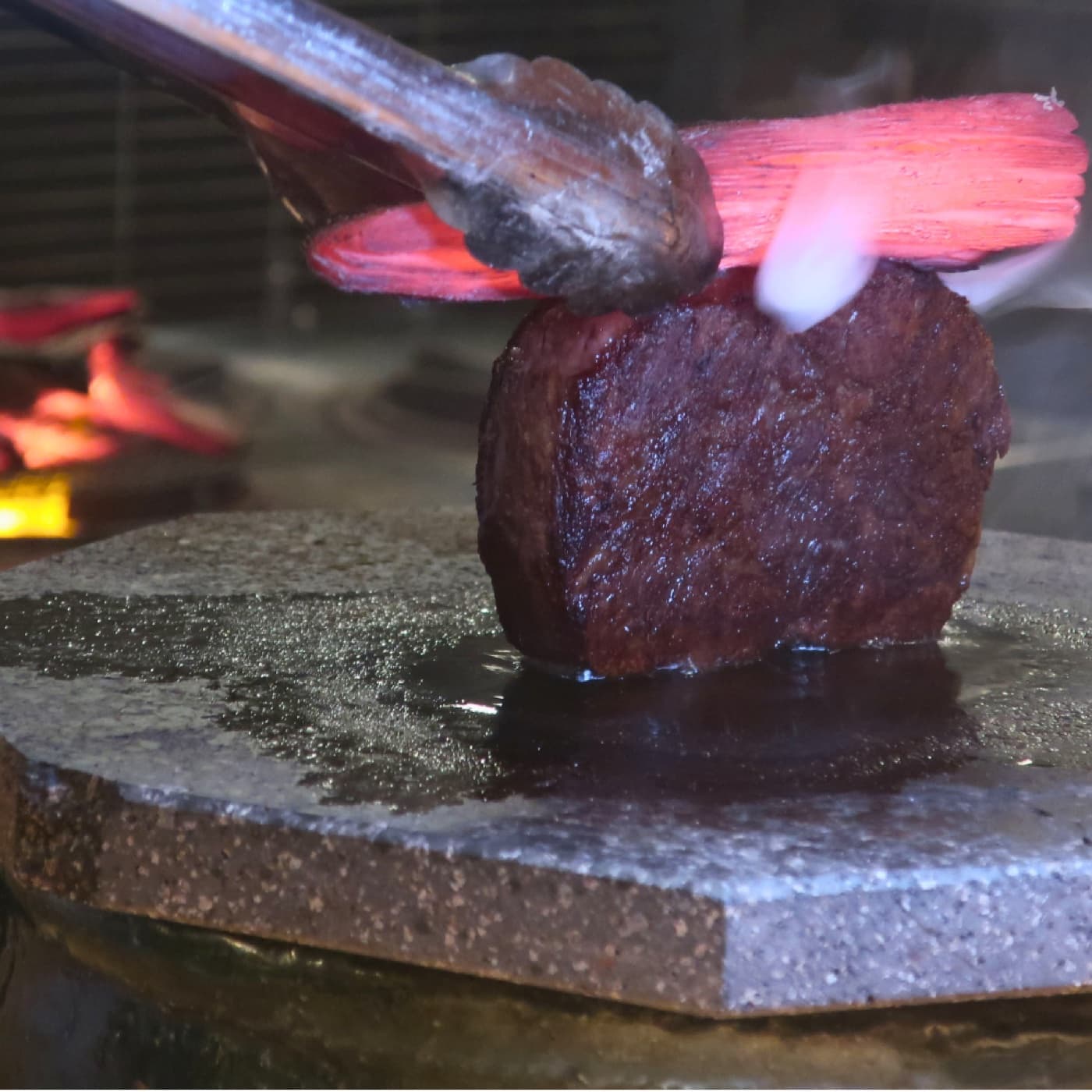 Kobe beef being seared on a hot stone